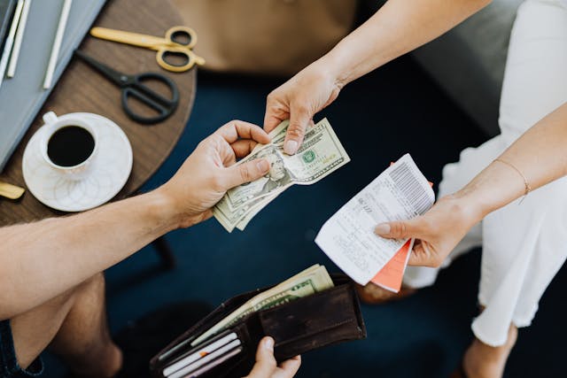 two-people-exchanging-money-with-one-person-holding-an-open-wallet